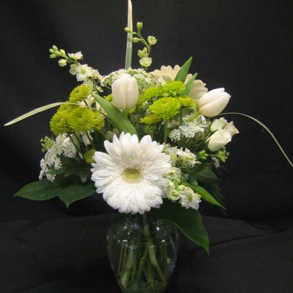 White and green floral arrangement in a glass vase