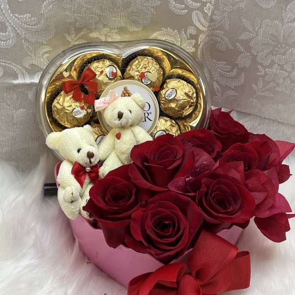 Red roses with teddy bears and chocolate candies in a heart-shaped box