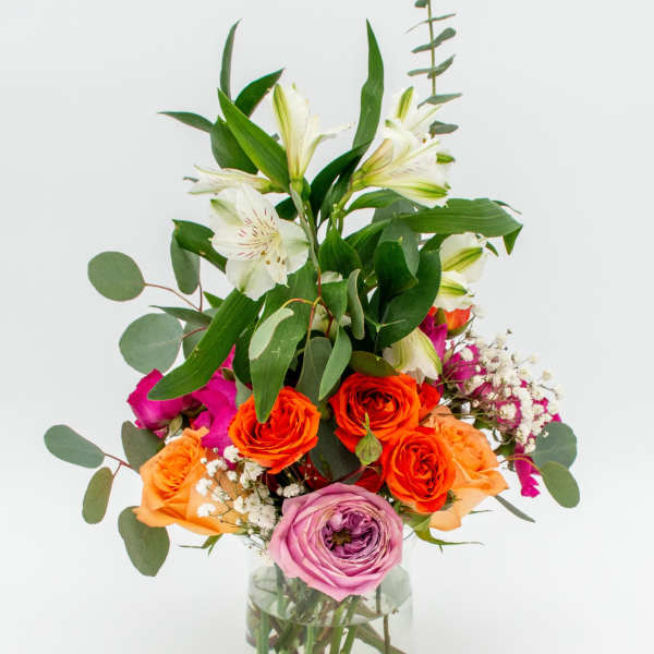 Mixed bouquet of roses and lilies in a glass vase