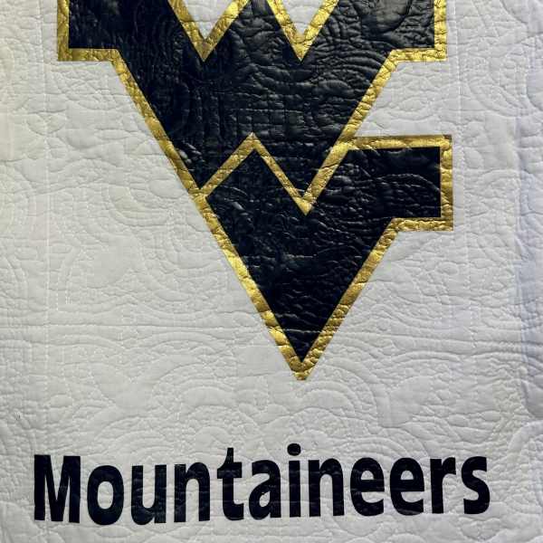Quilted West Virginia Mountaineers logo on white fabric