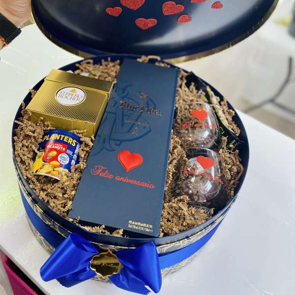 Gift box with chocolates, peanuts, and two glasses inside a round blue case