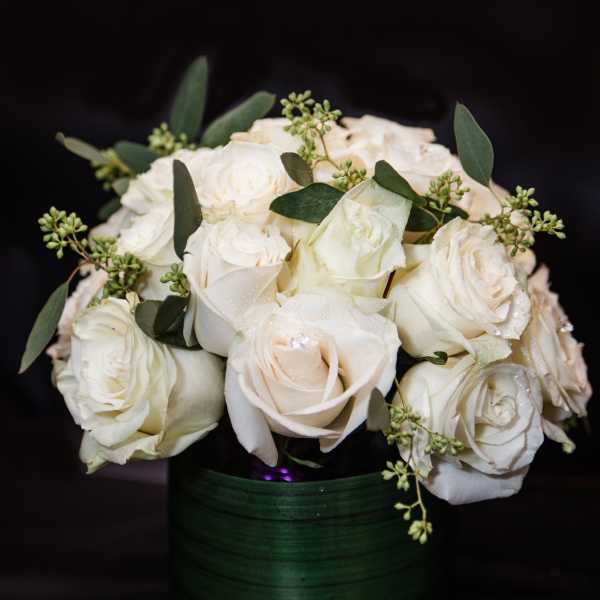 White rose bouquet in a dark green vase
