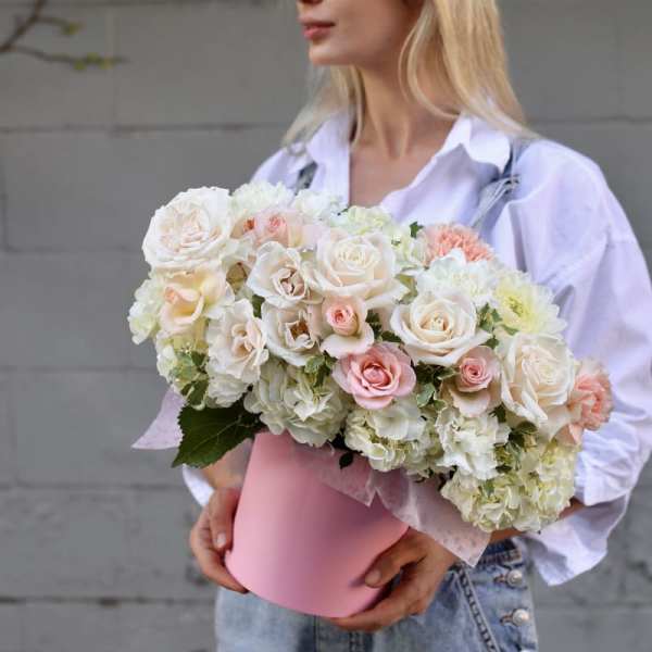 Bouquet of white and blush roses in a pink hatbox