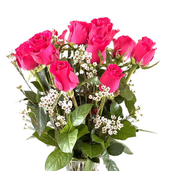 Pink roses arranged in a clear glass vase with small white filler flowers