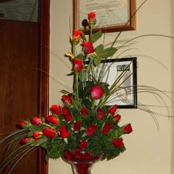 Tall red rose arrangement in a clear stemmed vase