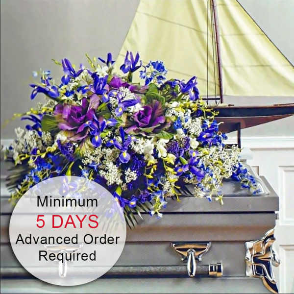 Purple and blue casket spray with white accents displayed on a gray casket