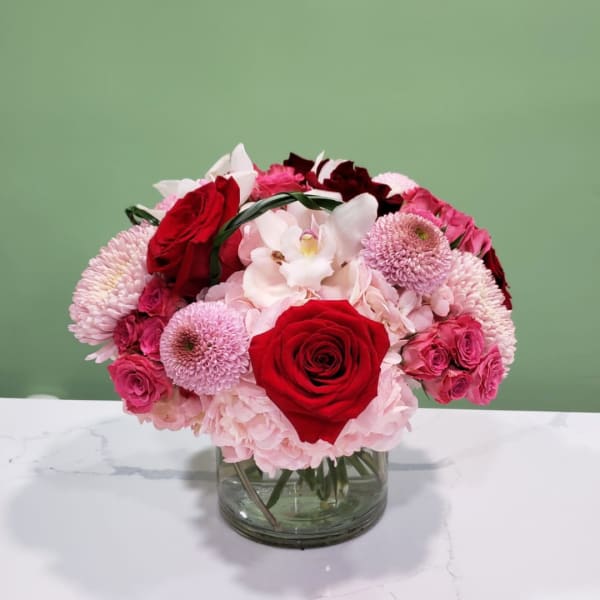 Bouquet of red and pink flowers in a clear glass vase