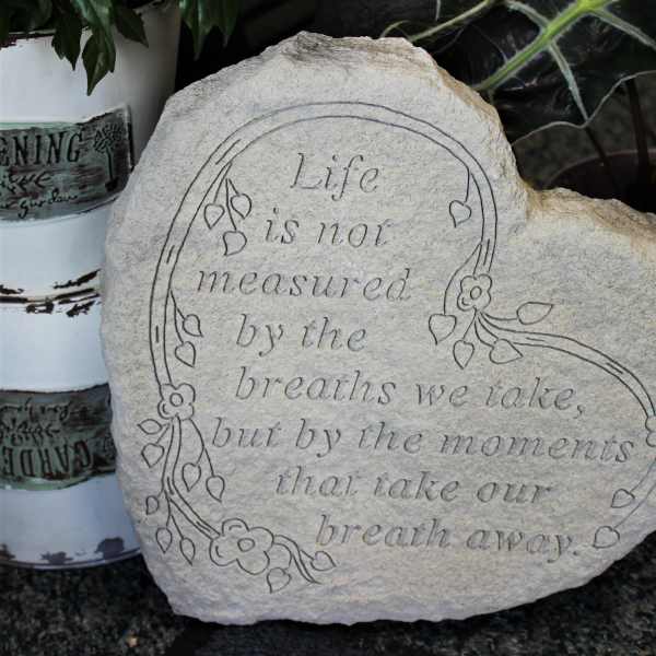 Engraved decorative stone with a floral border and quote
