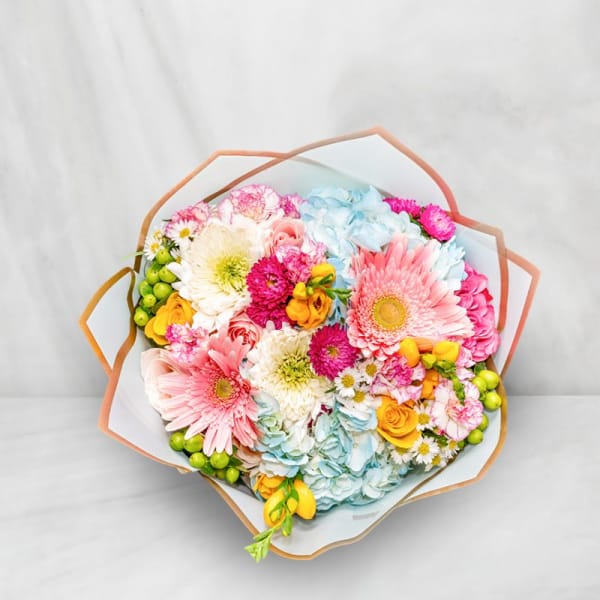Colorful bouquet with gerbera daisies, roses, and hydrangeas wrapped in paper