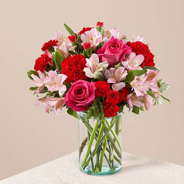 Pink roses and red carnations in a clear glass vase