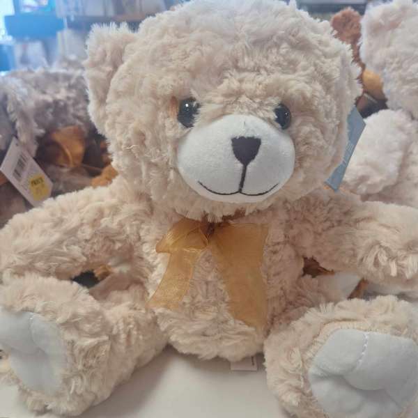 Plush teddy bear with a gold ribbon bow