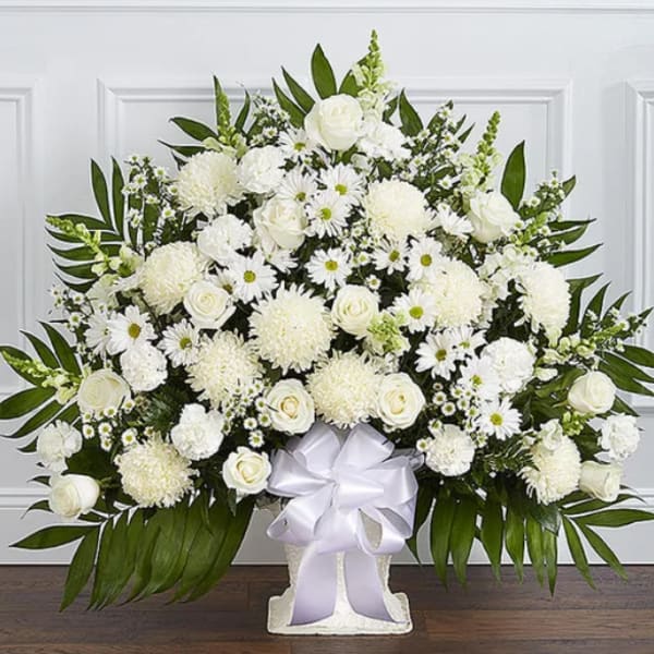 Large white floral arrangement in a vase with a white ribbon bow