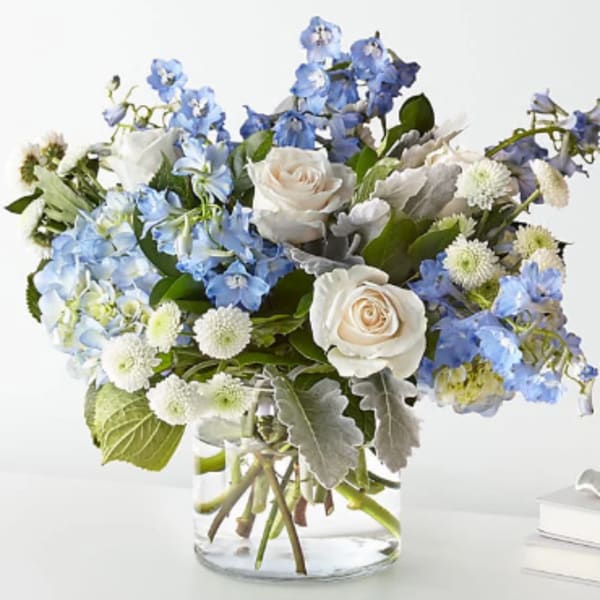 Blue and white flower arrangement in a clear glass vase
