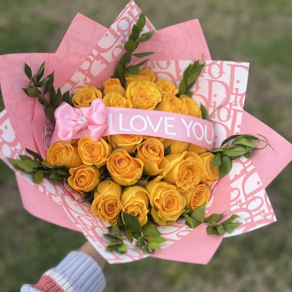 Bouquet of yellow roses wrapped in pink paper with an "I LOVE YOU" ribbon
