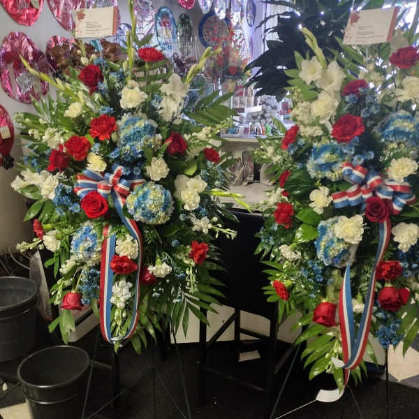 Two large standing floral sprays with red, white, and blue flowers