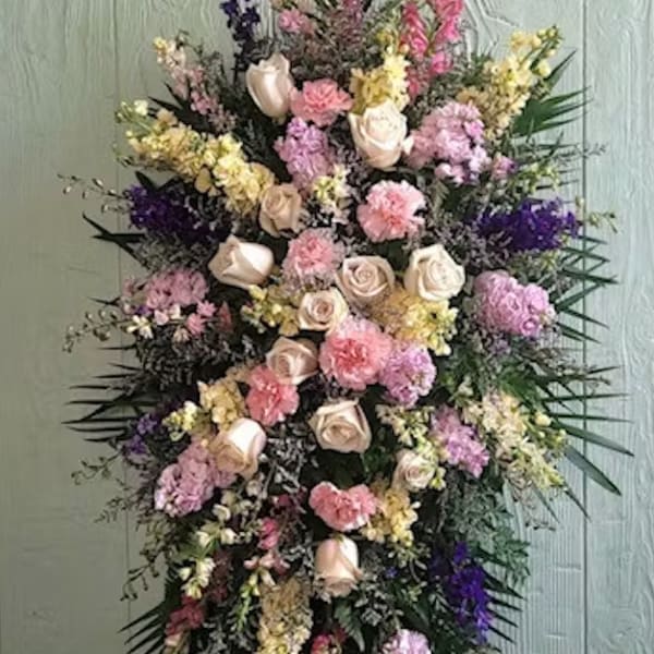 Tall standing floral spray with pink and cream roses and mixed pastel blooms