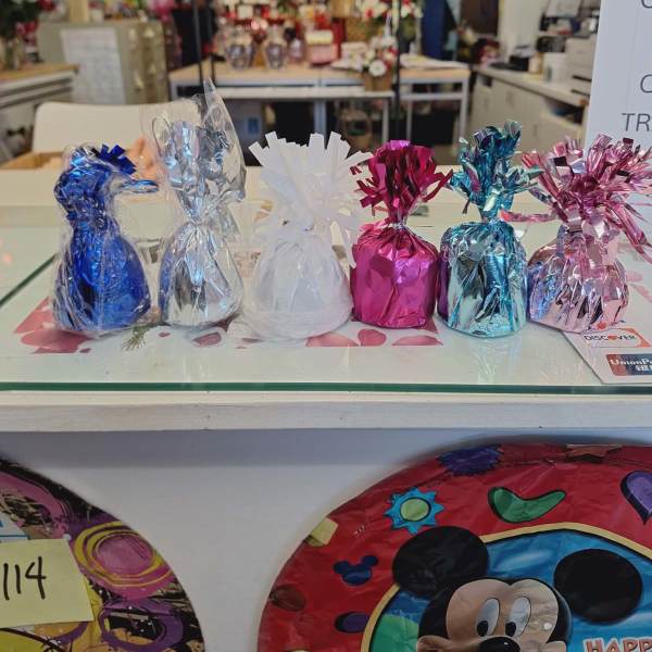 Foil-wrapped gift bags in blue, silver, white, pink, and teal on a counter