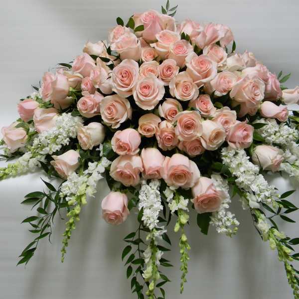 Large arrangement of pale pink roses with white trailing flowers