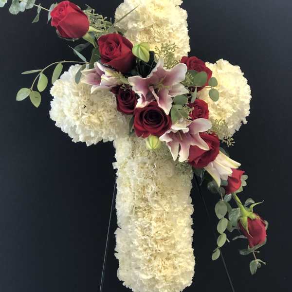 Cross-shaped floral tribute with red roses and white blooms