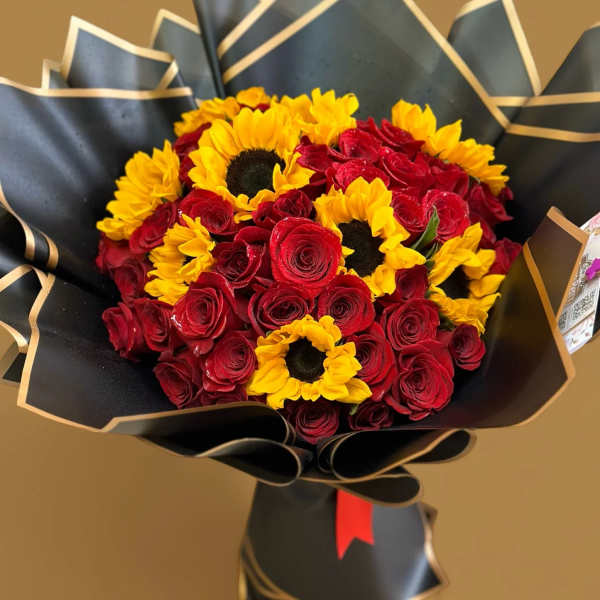 Bouquet of red roses and yellow sunflowers wrapped in black paper