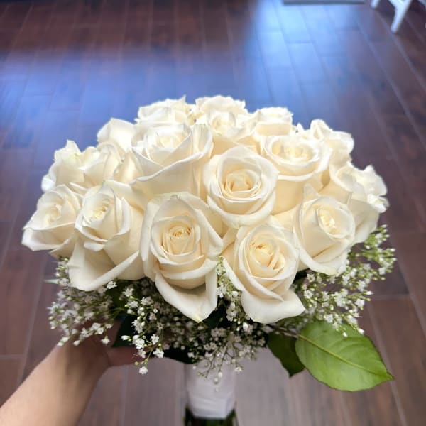 Bouquet of white roses with baby's breath and a single green leaf