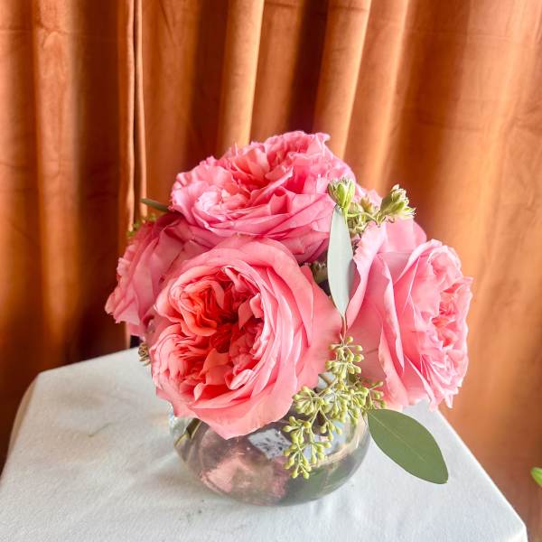 Pink roses arranged in a clear glass vase