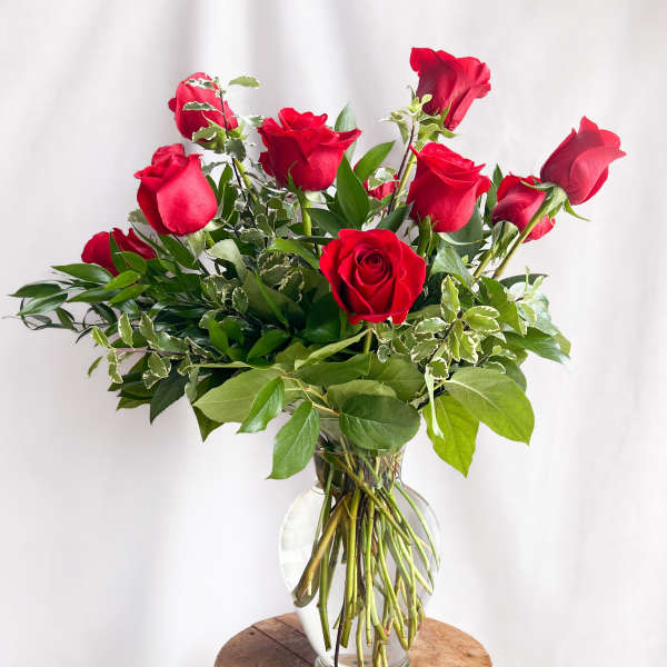 Red roses arranged in a clear glass vase