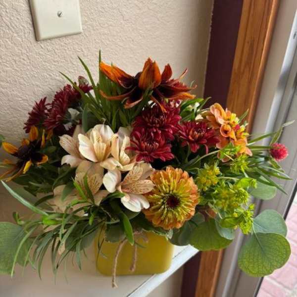 Mixed bouquet of chrysanthemums and alstroemeria in a yellow container