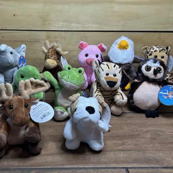 Assorted plush animal toys arranged on a wooden surface