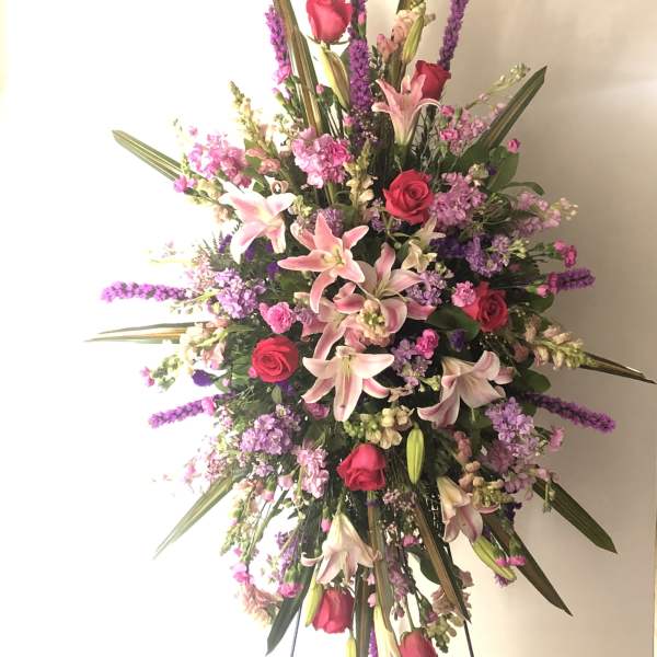 Large standing spray with pink lilies, red roses, and purple flowers
