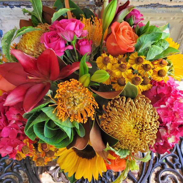 Mixed bouquet with roses, lilies, sunflowers, and orange pincushion blooms