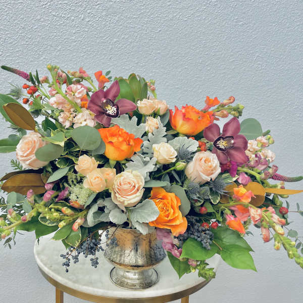 Mixed bouquet in a silver vase with orange and blush flowers