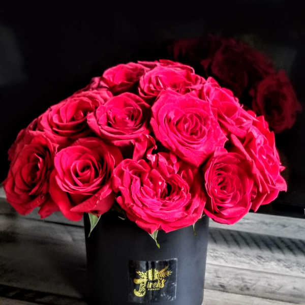 Bouquet of bright pink roses in a black hatbox
