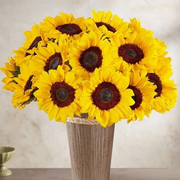 Bouquet of bright yellow sunflowers in a tall vase