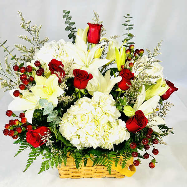 Basket arrangement of white lilies, red roses, and white hydrangea