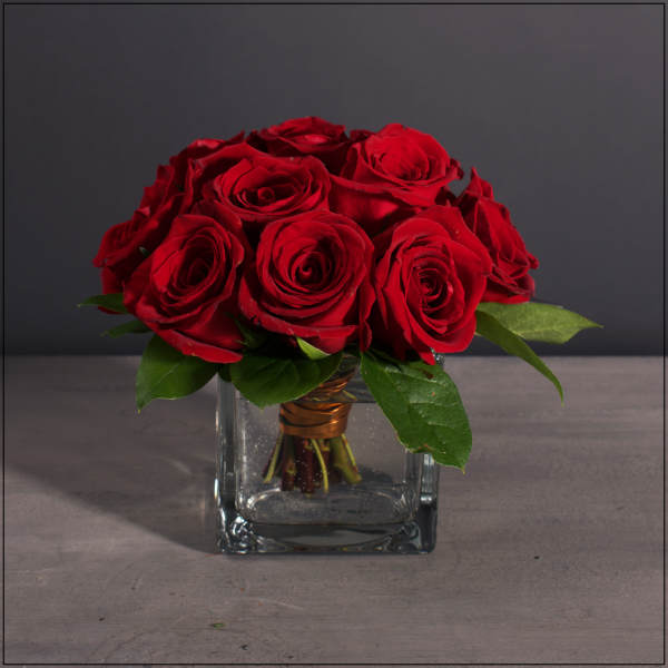 Red rose bouquet in a clear square glass vase