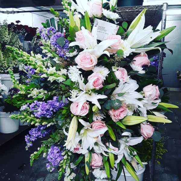 Large bouquet of white lilies, pink roses, and purple flowers