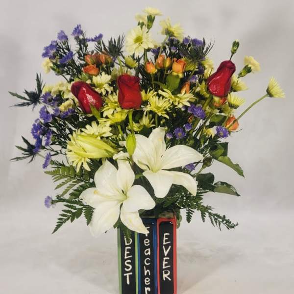 Mixed bouquet with white lilies, red roses, and purple flowers in a painted vase