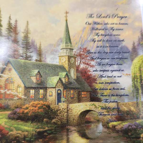 Decorative print of a stone church by a stream with the Lord's Prayer text
