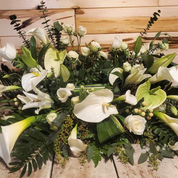 Large white floral arrangement with calla lilies and roses