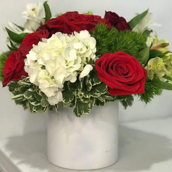 Red roses and white hydrangea in a white vase