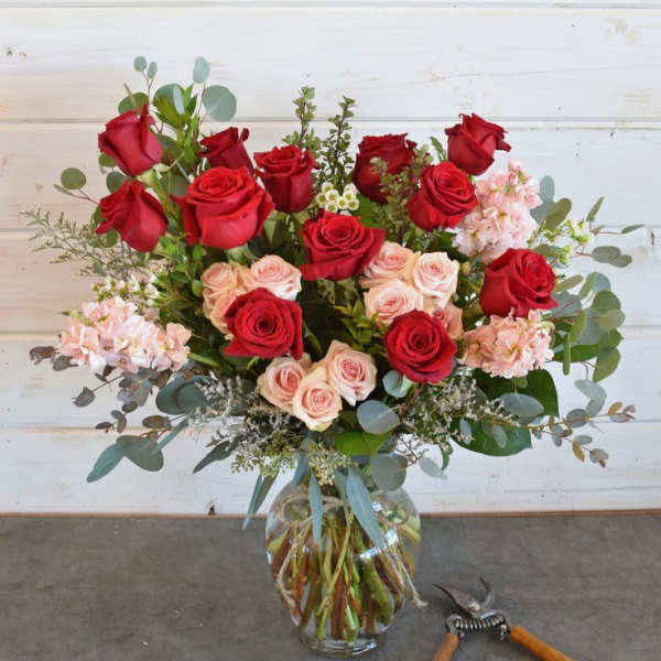 Bouquet of red and blush roses in a clear glass vase