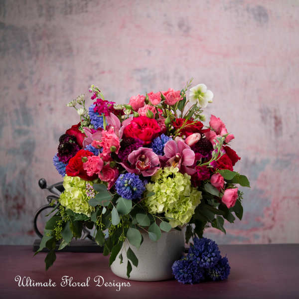 Mixed bouquet in a white vase with pink, red, purple, and green flowers