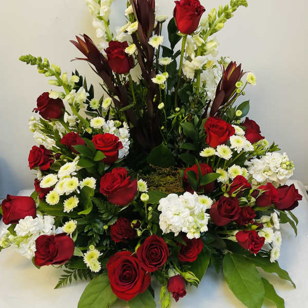 Red roses and white flowers in a large tiered arrangement