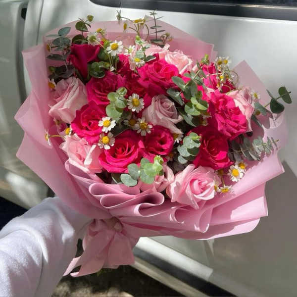 Pink rose bouquet with small white daisies wrapped in pink paper