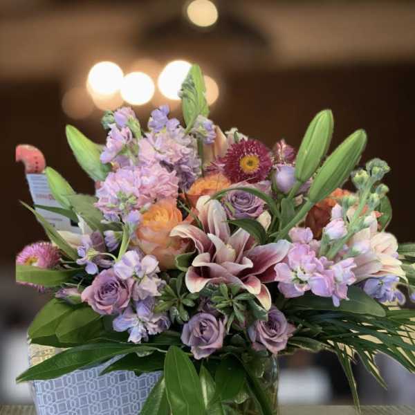 Mixed bouquet of pastel flowers in a glass vase