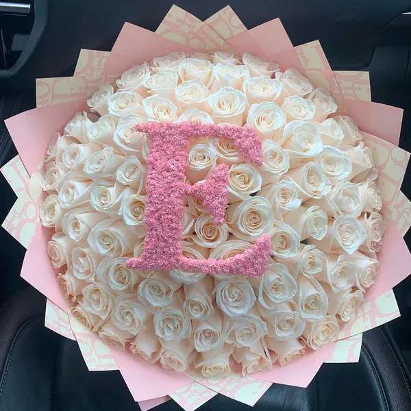 Large bouquet of white roses with a pink monogram topper