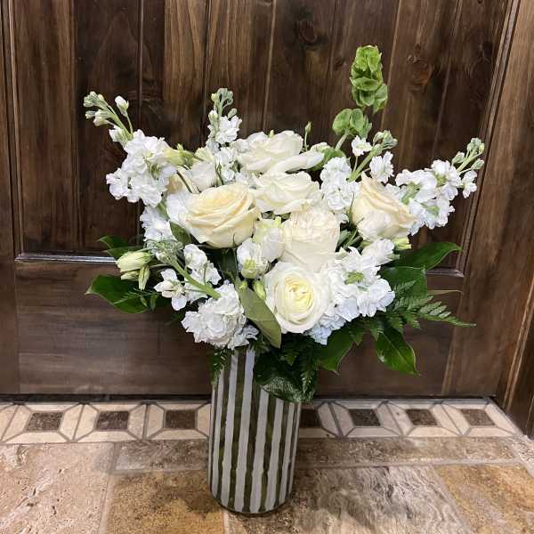 White roses and stock arranged in a striped vase