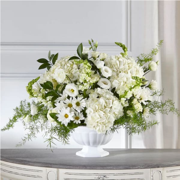 White floral arrangement in a white pedestal vase