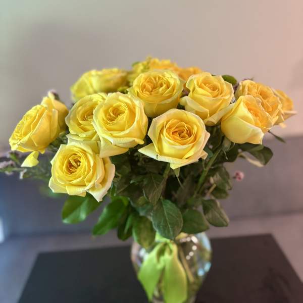 Yellow roses arranged in a clear glass vase